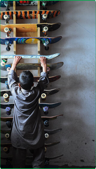 Person stacking skateboards.